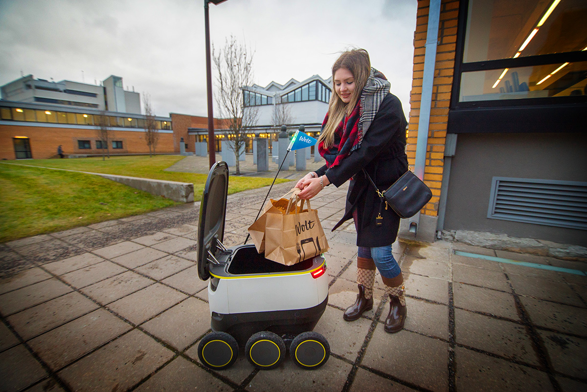 A student at Tallinn University of Technology receives one of the first-ever food deliveries by a robot in Tallinn in autumn 2016. (Image: Wolt)